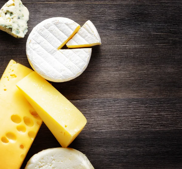 Different types of cheese on a wooden board — Stock Photo, Image
