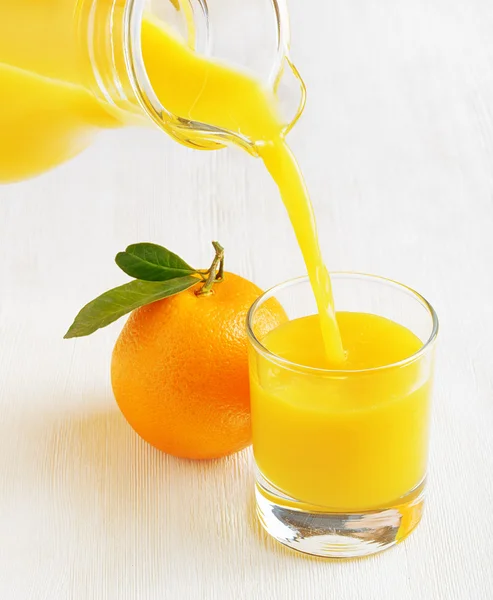 Sklenice pomerančové šťávy na stůl — Stock fotografie