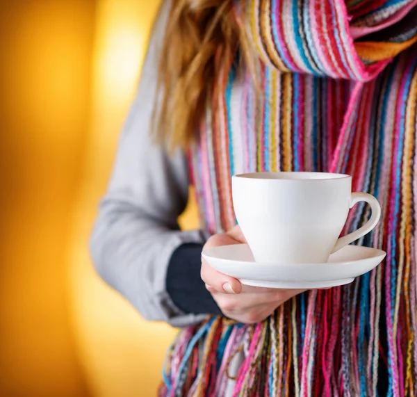 Молодая женщина держит чашку кофе в кафе — стоковое фото