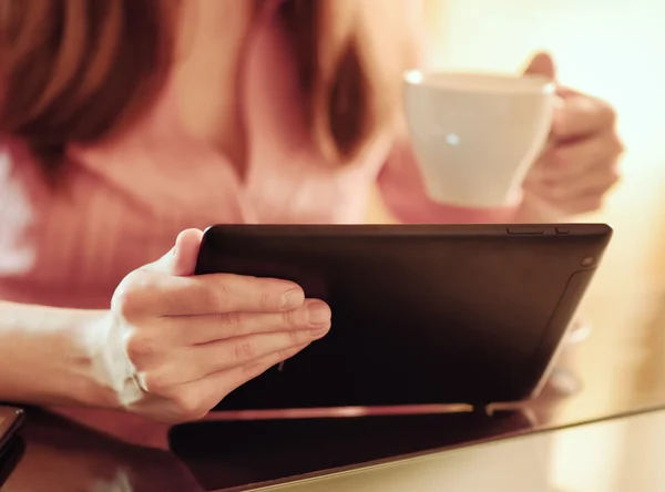 Молодая женщина использует планшетный компьютер в кафе — стоковое фото