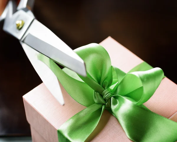 Dekorowanie pudełko z zieloną wstążką za pomocą nożyczek — Zdjęcie stockowe
