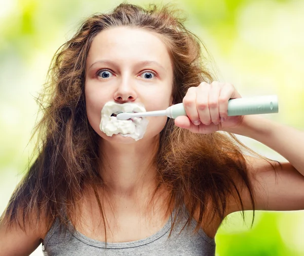 Shaggy giovane donna utilizzando spazzolino da denti elettrico — Foto Stock