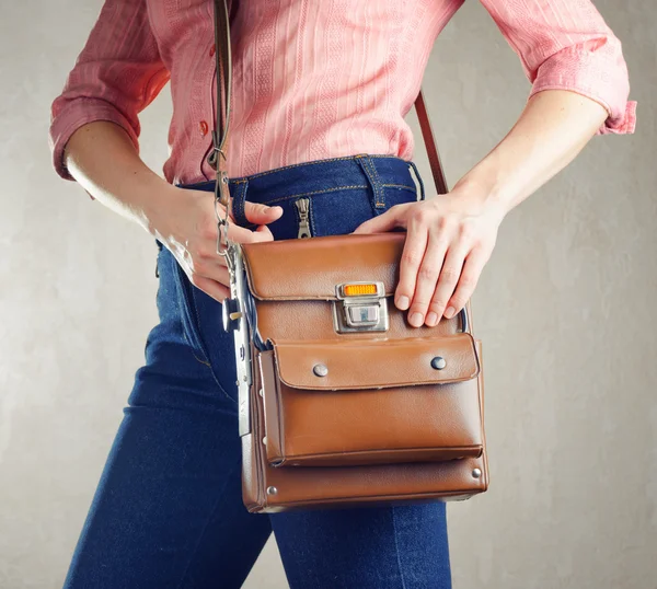 Mujer joven en pantalones vaqueros azul profundo sosteniendo una bolsa — Foto de Stock