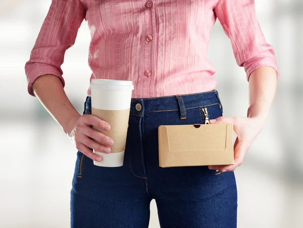 Mujer joven en pantalones vaqueros azul profundo sosteniendo un café —  Fotos de Stock