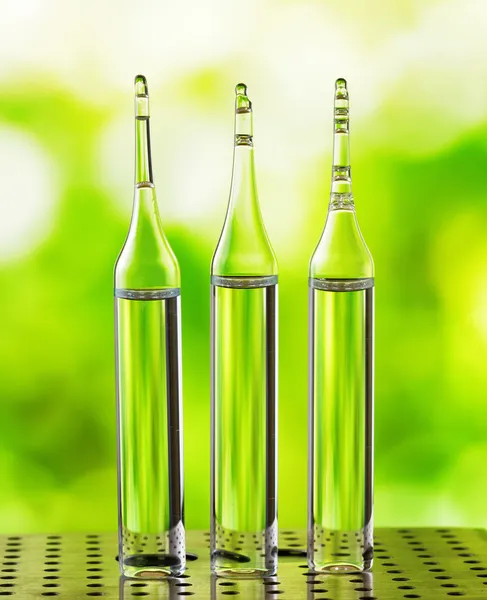 Three ampoules on nature background — Stock Photo, Image