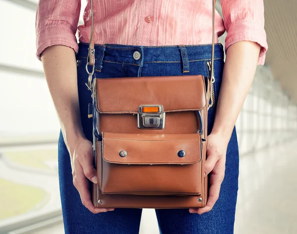 Young woman in deep blue jeans holding a bag — Stock Photo, Image