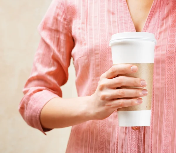 Junge Frau hält einen Becher Kaffee in der Hand — Stockfoto