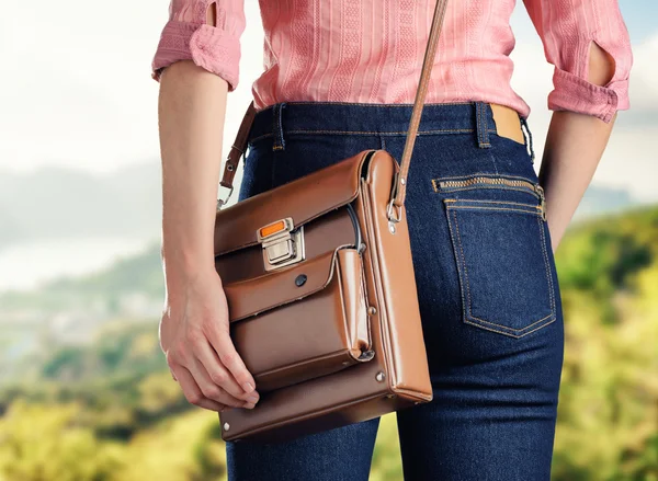 Young woman in deep blue jeans holding a bag — Stock Photo, Image