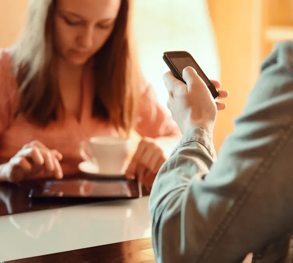 Pareja ignorándose unos a otros ocupados con sus dispositivos móviles — Foto de Stock