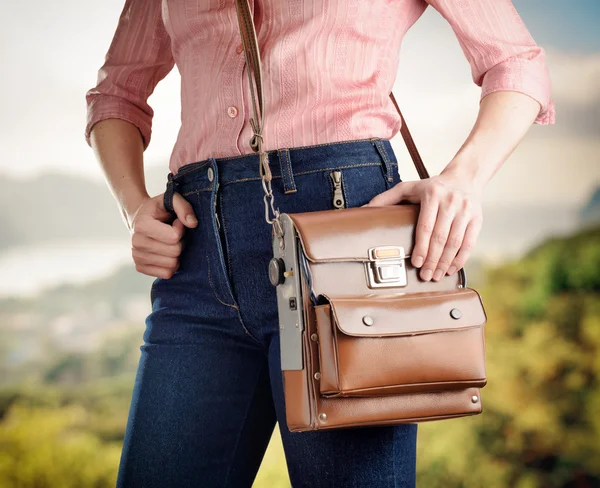 Jeune femme en jean bleu profond tenant un sac — Photo