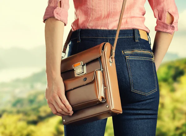 Jeune femme en jean bleu profond tenant un sac — Photo