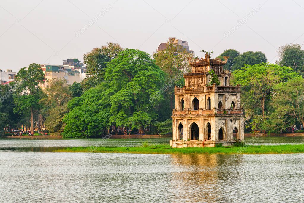 Sunset view of the Turtle Tower in middle of the Hoan Kiem Lake (Lake of the Returned Sword) at historic centre of Hanoi in Vietnam. The Turtle Tower is a popular tourist attraction of Asia.