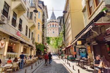 İstanbul, Türkiye - 15 Eylül 2021: Eski dar bir sokaktan Galata Kulesi 'nin manzarası. İstanbul dünyada popüler bir turizm beldesi.