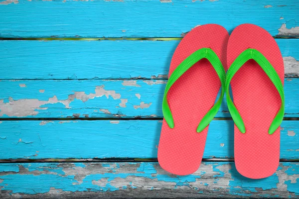 Rode ang groene flip flop sandalen op blauwe hout Rechtenvrije Stockafbeeldingen