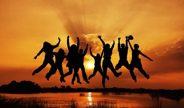 Crowd of friends jumping on blue sky background — Stock Photo, Image