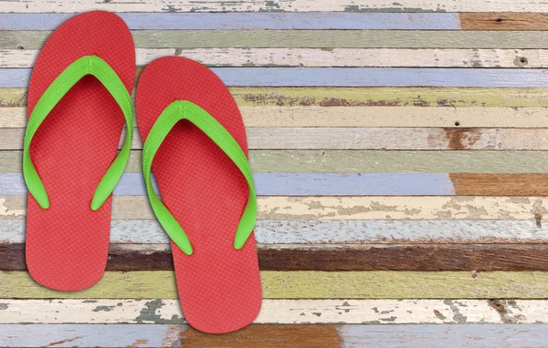 Červené a zelené pantofle sandále na staré dřevo malba — Stock fotografie