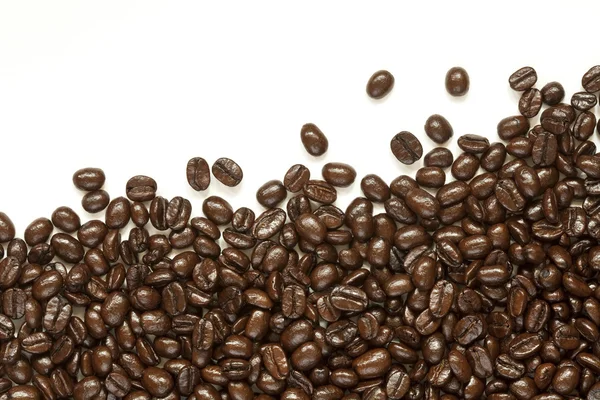 Muchos granos de café sobre fondo blanco — Foto de Stock