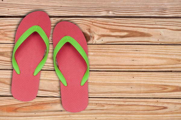 red ang green flip flop sandals on wood background