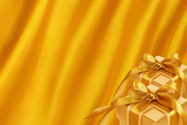 ゴールド サテン背景に金ギフト ボックス — ストック写真