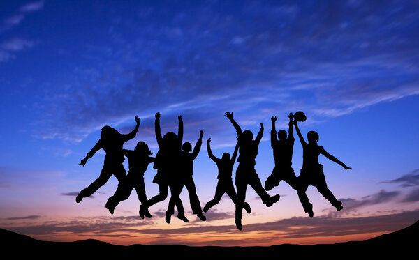 Crowd of friends jumping on blue sky background