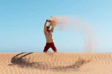Bekar adam Namib çölüne kum atıyor.