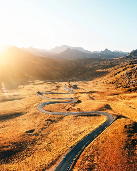 Increíble vista aérea sobre la sinuosa carretera en otoño valle de la montaña al atardecer — Foto de Stock