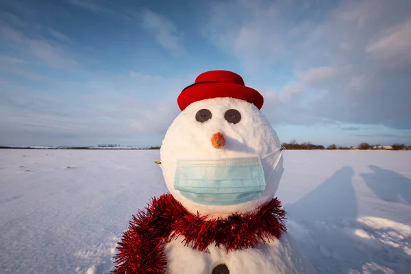 Смішний сніговик у стильній червоній шапці з медичною маскою — стокове фото