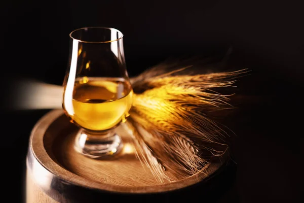 A glass of whiskey on oak barrel — Stock Photo, Image