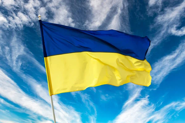 Український синій і жовтий двокольорові національний прапор на синьому тлі неба — стокове фото