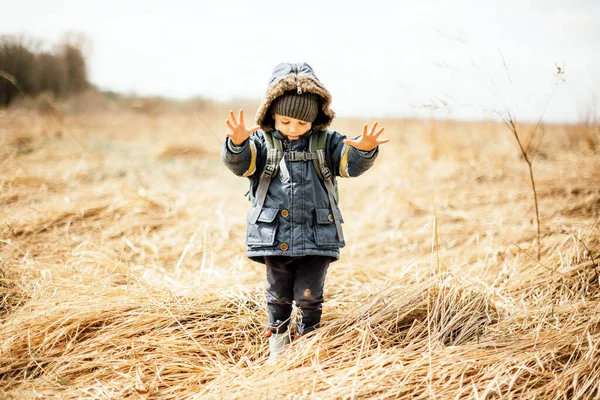 Piccolo bambino nel campo di erba secca gialla — Foto Stock