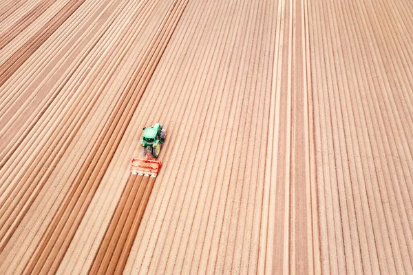 Tractor solitario en el campo agrícola con hileras de tierra arada —  Fotos de Stock