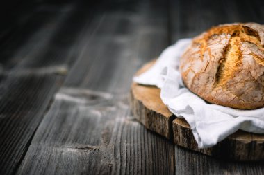 Geleneksel mayalanmış mayalı ekmek. Köy ahşap bir masada derisi pişmiş. Sağlıklı yemek fotoğrafçılığı