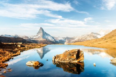 Stellisee Gölü üzerinde renkli gündoğumu olan resim gibi bir manzara. Karlı Matterhorn Cervino zirvesi berrak suda yansıyor. Zermatt, İsviçre Alpleri
