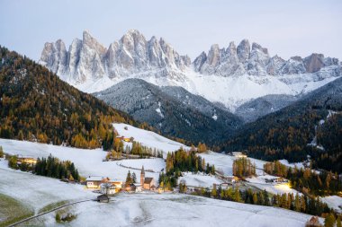 Famous Santa Magdalena mountain village with Church Chiesa di Santa Maddalena in the autumn Dolomites. Snowy Gruppo delle Odle mountain range in the background. Val di Funes, South Tyrol, Italy