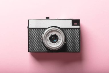 Old film retro camera on pink background. Photography concept