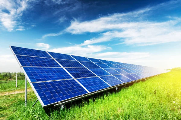 青い空の背景に太陽電池パネル 緑の草と曇りの空 代替エネルギーの概念 — ストック写真