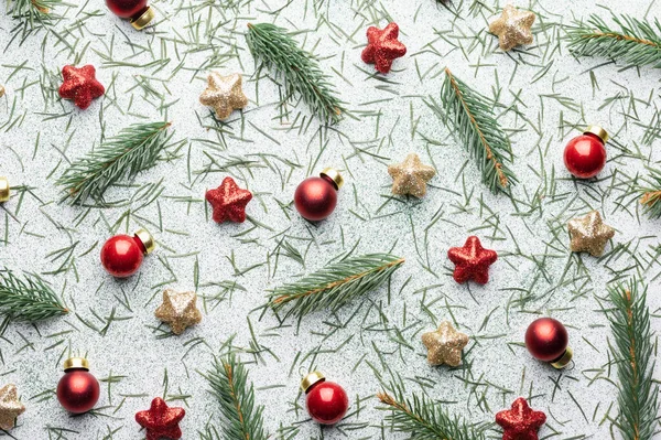 白い背景にクリスマスボール 松の小枝 赤と金色の星の装飾と創造的なクリスマスの背景 フラットレイアウト トップビュー コピースペース — ストック写真
