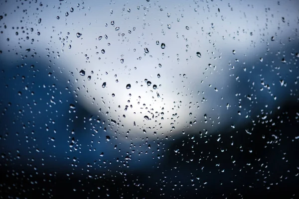 蓝色背景的窗玻璃上的雨滴 有选择的重点 多雨的城市背景 — 图库照片