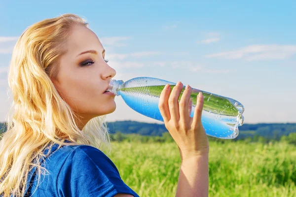 Νεαρή γυναίκα πόσιμο νερό από το μπουκάλι — Φωτογραφία Αρχείου