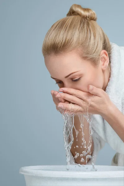 Young woman washing her face Stock Photo
