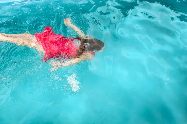 Uma jovem nadando debaixo d 'água na piscina — Fotografia de Stock