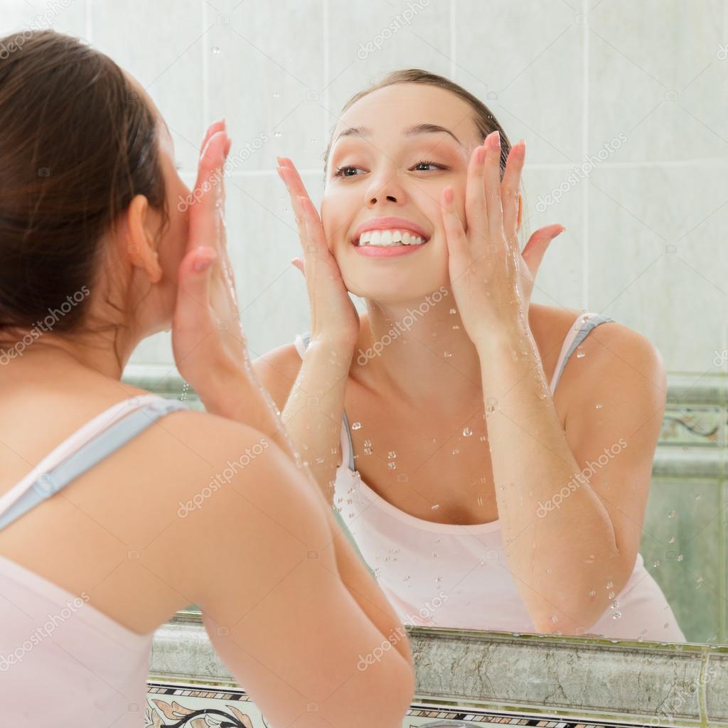 Young woman washing her face with clean water — Stock Photo © Avesun