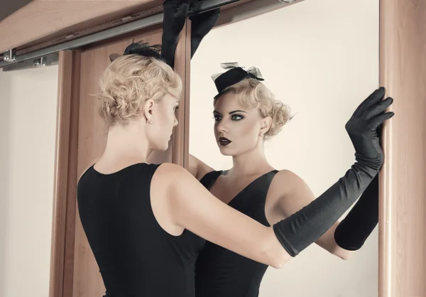 Elegant woman looking at herself in the mirror — Stock Photo, Image