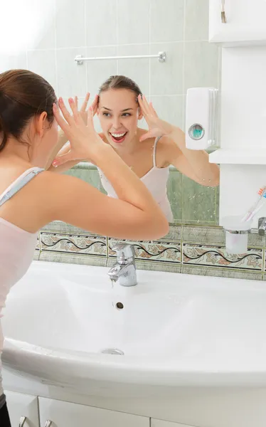 Jeune femme se lave le visage avec de l'eau propre — Photo