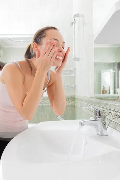 Junge Frau wäscht ihr Gesicht mit sauberem Wasser — Stockfoto