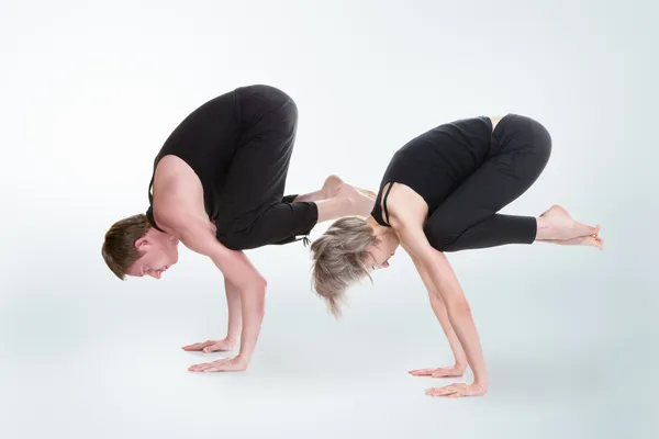 Hombre y mujer haciendo yoga en pose de grúa bakasana —  Fotos de Stock