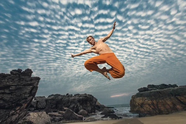 Joven salto de altura en la playa —  Fotos de Stock