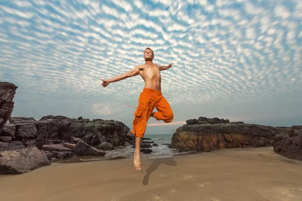 Młody człowiek, wysokie skoki na plaży — Zdjęcie stockowe