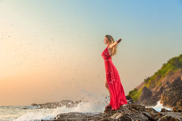 Жінка в довгій сукні перед морем — стокове фото