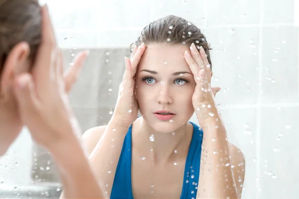 Junge Frau wäscht ihr Gesicht — Stockfoto